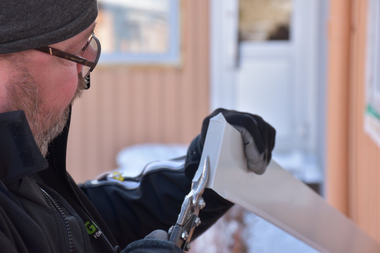 Montör från JL Fönster & Fasad arbetar med plåt vid ett fönster