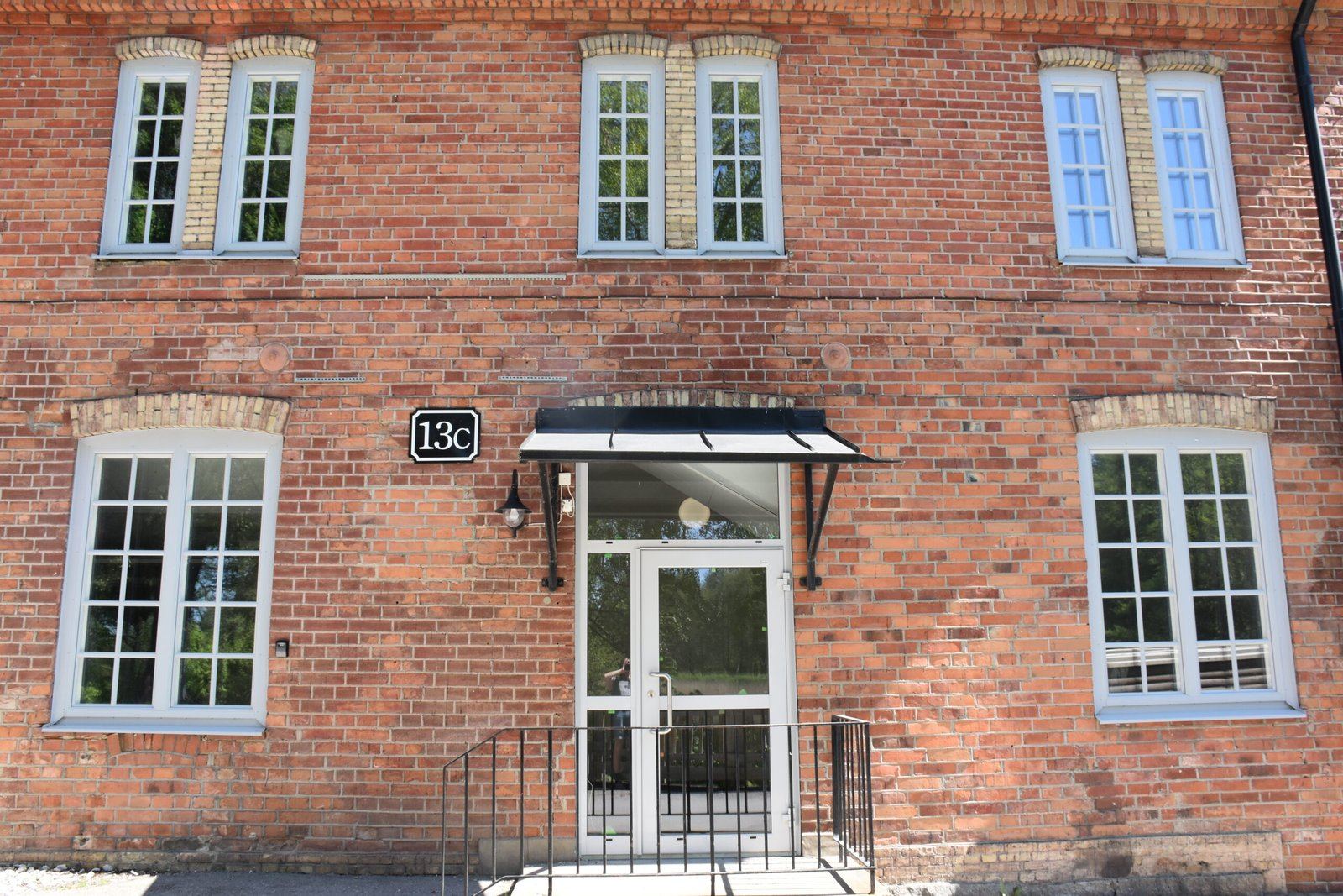 Entré och spröjsade fönster i tegelfasad
